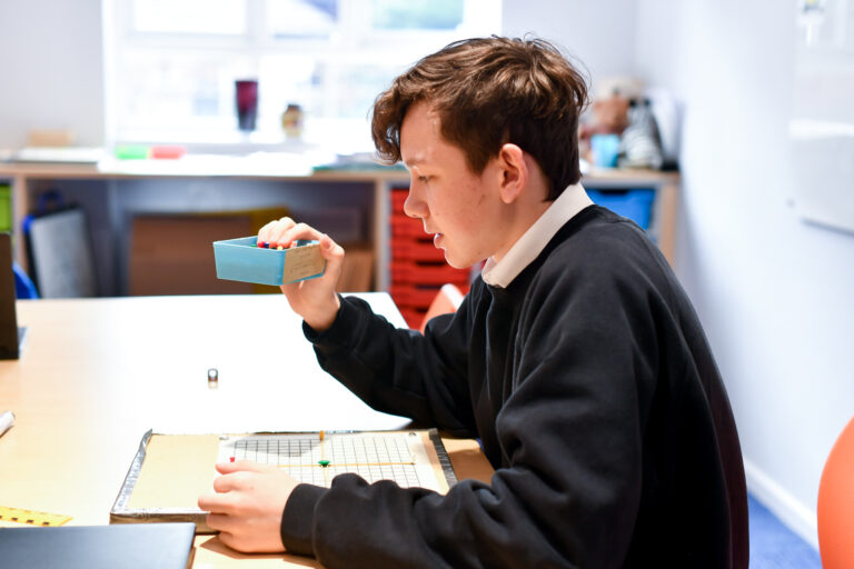 Student in Maths classroom using pins to create a tactile diagram