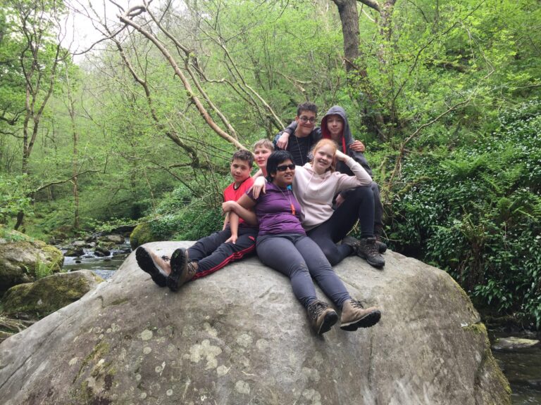 Students sat on a rock together