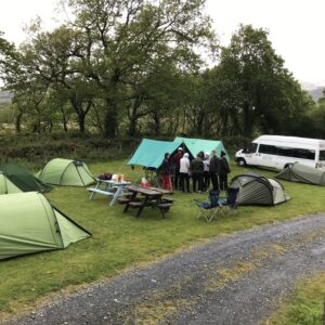 Wider view of the camp set up around two picnic benches and the NCW van in the background