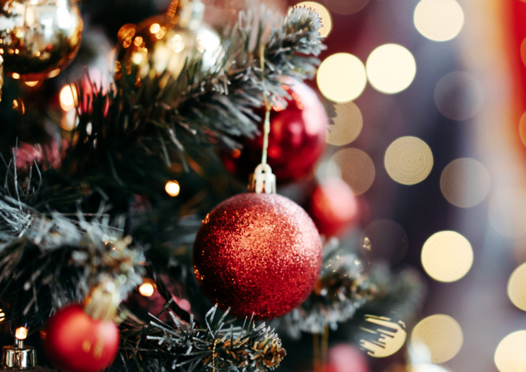 close up of a christmas tree with red baubles and lights