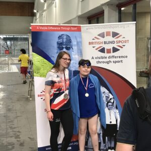 Roman with Rebecca Redfern posing for a photo on the side of the pool