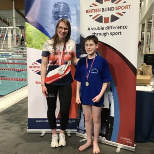 Maxwell with Rebecca Redfern posing for a photo on the side of the pool