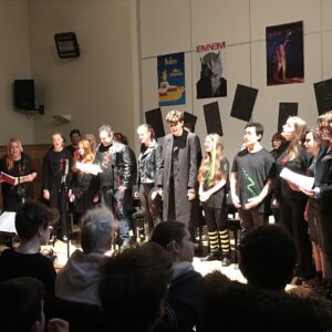 The cast standing, dressed in grunge and rock clothes!