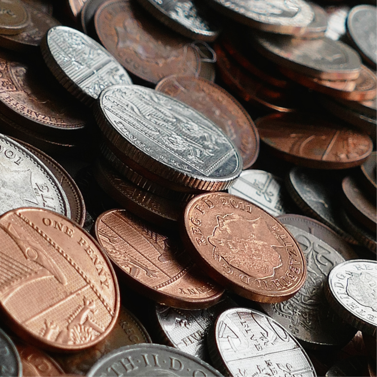 image is a close up of various coins. Some are copper and some are silver.