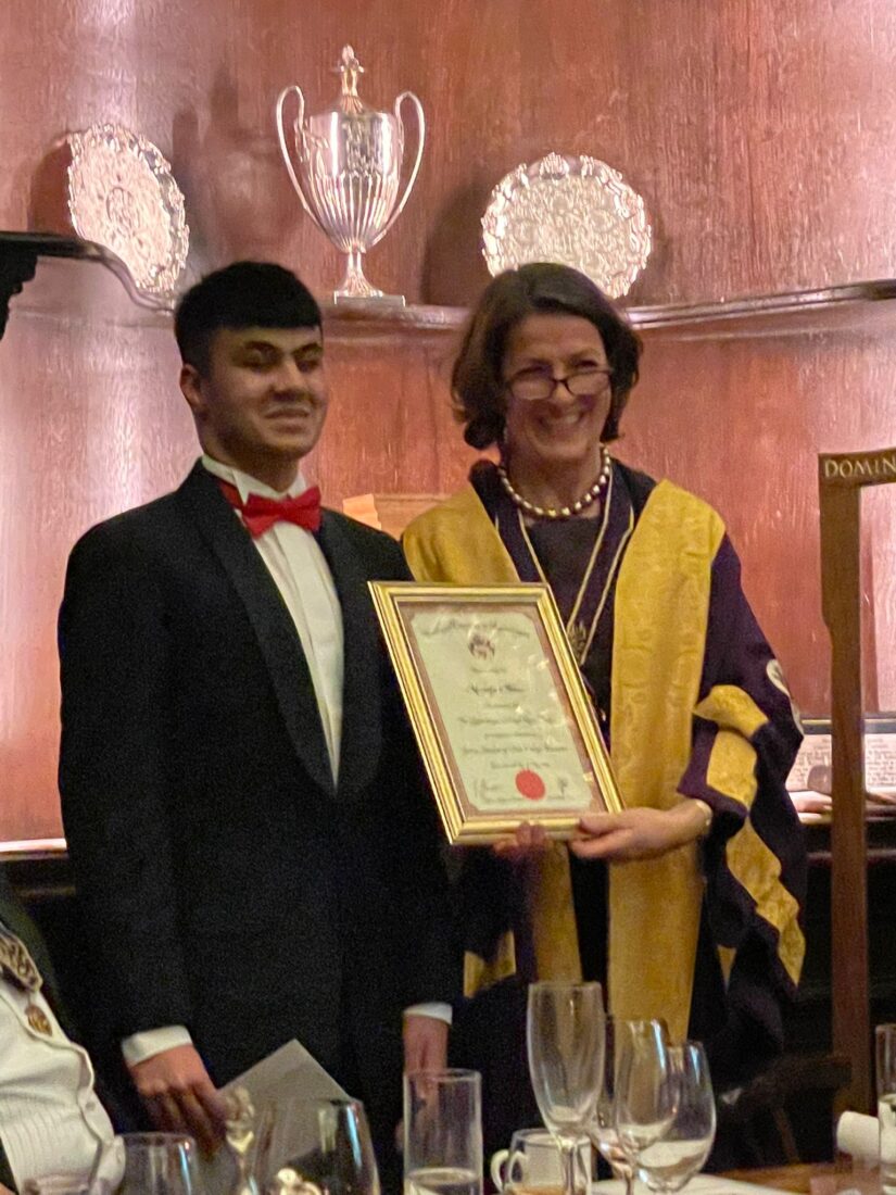 Mustafa is presented with an award from Master Margaret Fitzsimons, for his commitment as Head Student for 2021/22