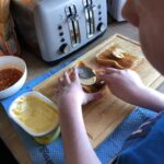 Student is buttering toast with the back of a spoon