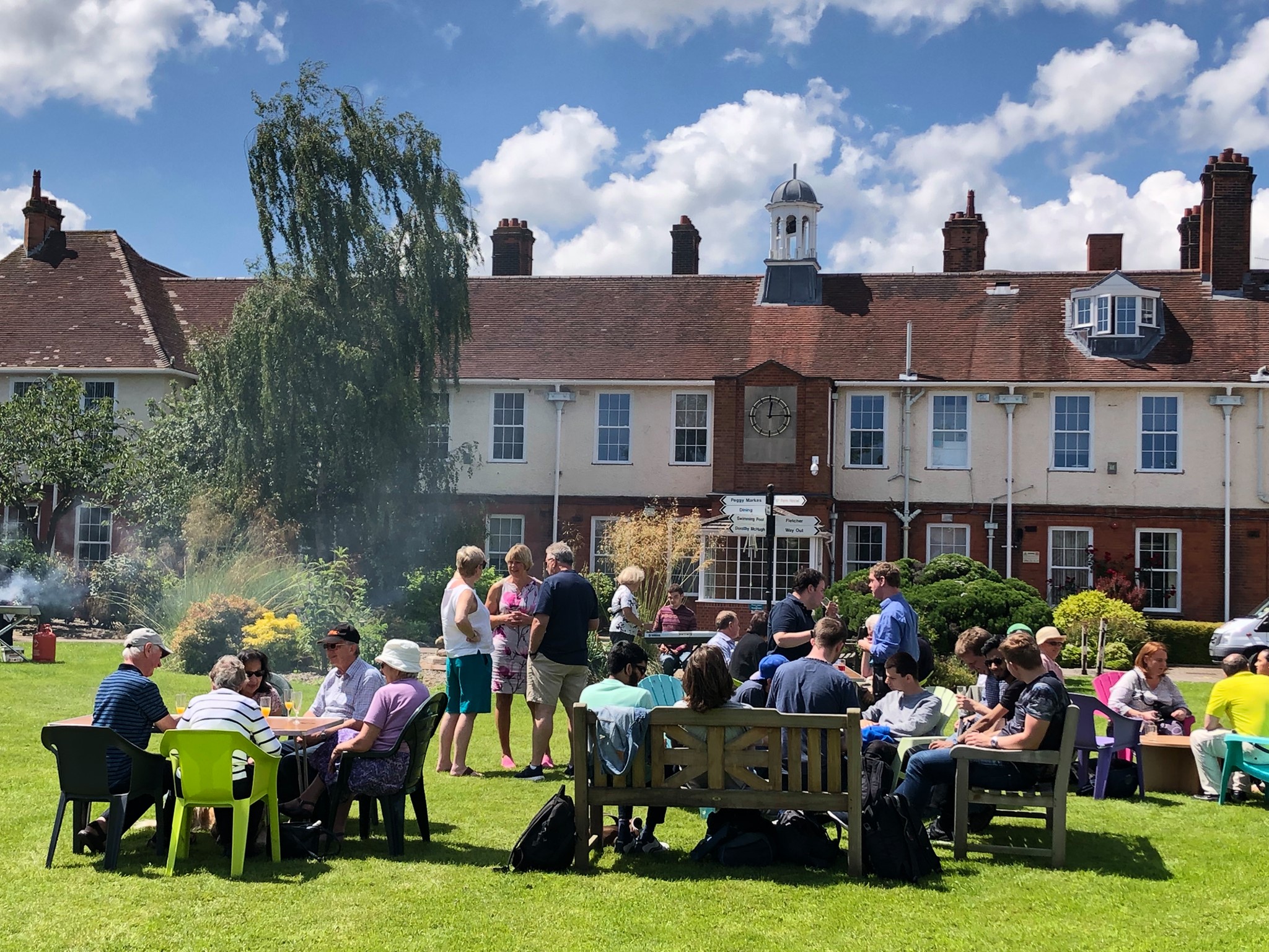 image of people enjoying a BBQ on the lawn outside NCW by the fountain