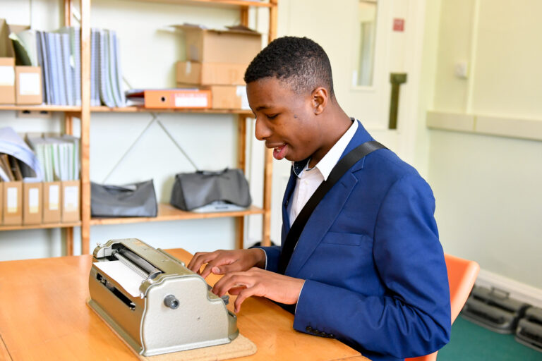 image of a student working in a braille lesson