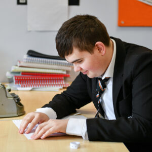 A male student reading Braille