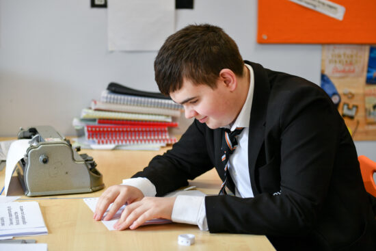 A male student reading Braille