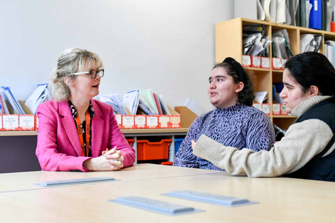 image of Mrs Perks with two students during a lesson