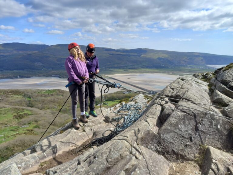 image of a student and staff scrambling on rocks