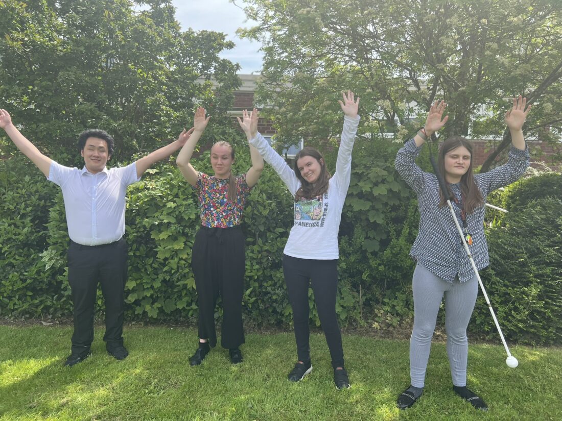 image of all four students on the lawn cheering