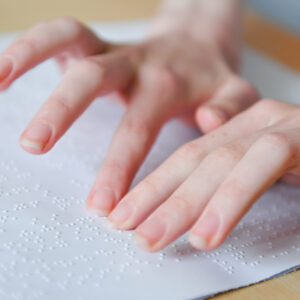 image of a students hands reading printed braille