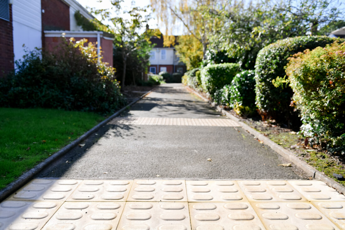 close up of the tactile paving in the mobility training area, the school building can be seen in the background