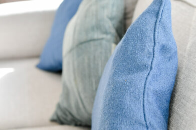 close up of three blue and light blue cushions on the sofa