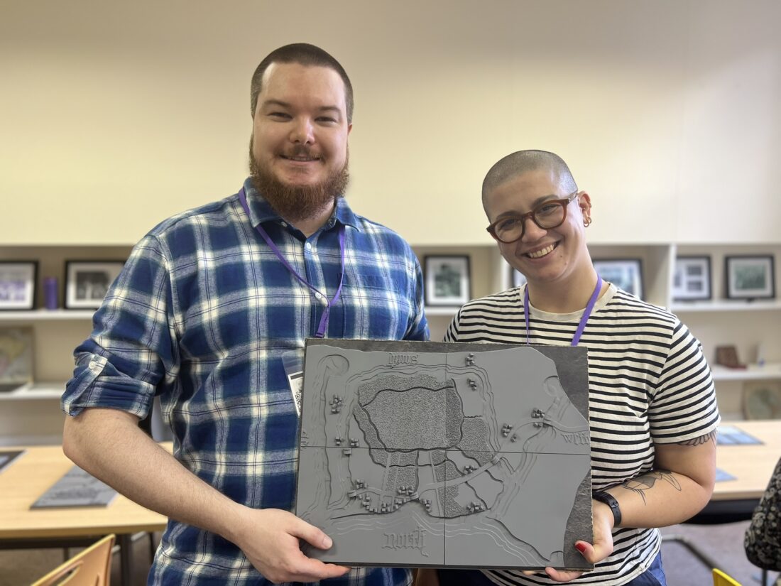 George Rhodes, of the University of Westminster, and Maria Kaffa smiling at the camera whilst holding a model