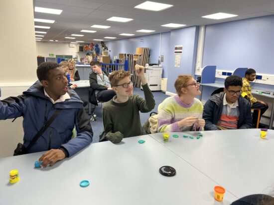 Image of students sat at a table using playdough