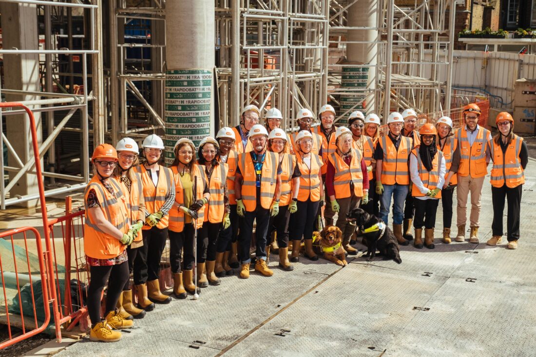 Group photo of the focus group on the building site hearing high vis jackets and hard hats